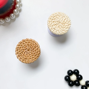 Detail of round rattan-style phone sockets in beige and wood colors with woven texture