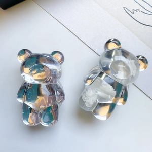 Macro view of two transparent resin bear phone sockets with glossy finish on desk