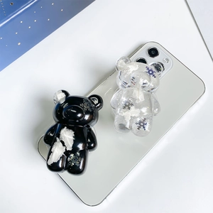 Detail shot of bear-shaped phone grips with snowflake glitter inside in black and clear colors