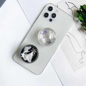 Detail of 3D spherical phone grip with snowflake glitter and cloud filling on a white phone