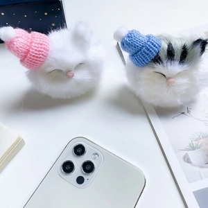 Detail of plush cat phone socket featuring cute knit hats and soft fluffy textures