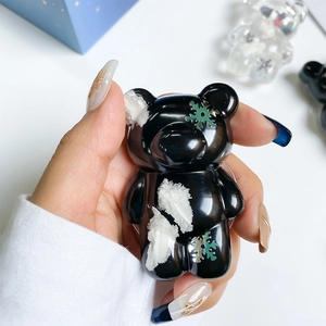 Detailed view of a black bear cell phone stand with snow textures and snowflake accents
