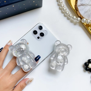 Glittery cloud bear phone grip stand on a white smartphone with stylish accessories