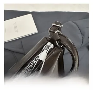 Close-up of premium silver metal zipper hardware on minimalist dark PU leather handbag
