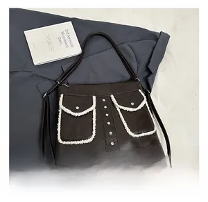 Detail of dark brown tote bag featuring plush faux fur trim pockets and silver rivets