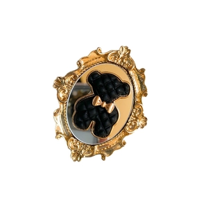 Vintage gold relief floral frame phone socket with a black quilted bear on a mirror finish