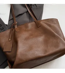Close-up of the vintage brown leather tote bag texture with a minimalist square tag