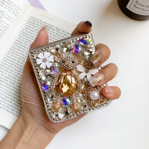 Luxury rhinestone bear and pearl floral phone case for Samsung Z Flip3 shown in hand