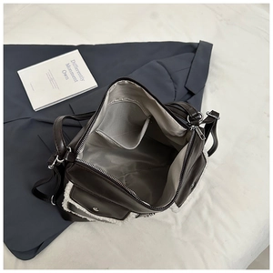 Detailed interior of a large brown crossbody bag with plush trim and inner pocket