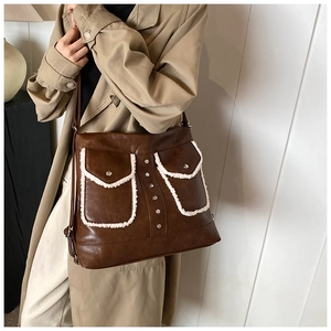 Close-up of coffee brown tote bag featuring sherpa trim pockets and silver rivet details