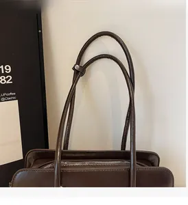 Détail des anses et de la fermeture éclair d'un sac à main marron élégant