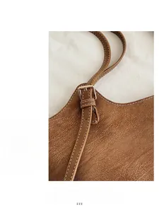 Detail of vintage brown leather tote bag with light gold buckle and contrast stitching