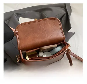 Detailed interior of brown PU leather crossbody bag showing spacious main compartment