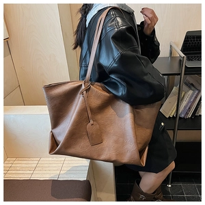 Detail of the high-quality soft PU leather texture on a large brown tote shoulder bag