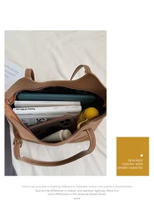 Top view of large capacity brown leather tote bag interior showing books and iPad
