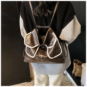Detail of dark brown backpack with white plush fleece trim and silver rivet accents