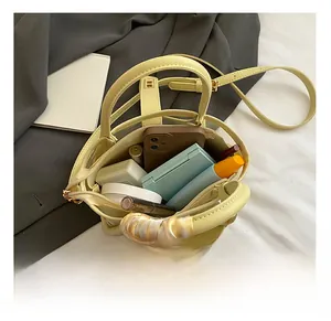 Internal view of a yellow leather bucket bag showing capacity for phone and cosmetics