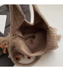 Détail d'un sac cabas en tricot bohème montrant le design ouvert et le pompon latéral
