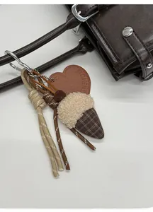 Détail du bijou de sac vintage avec cœur en cuir et pendentif gland en peluche doux