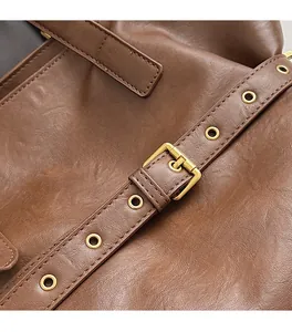 Close-up of golden hardware and rivets on vintage brown leather tote bag