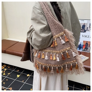 Détail d'un sac bohème en tricot avec des pompons à trois couches et des plumes stylées
