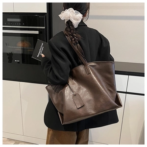 Large dark brown tote bag in vintage faux leather shown in a modern home lifestyle setting