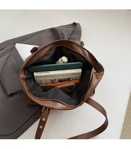 Interior view of large brown tote bag showing spacious capacity for books and tablet