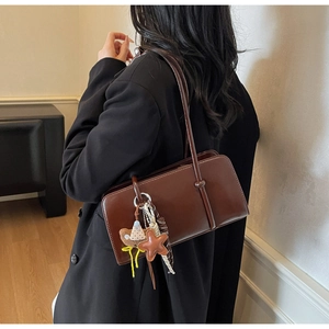 Détail du sac baguette marron foncé avec breloque ours mignonne et pendentif étoile