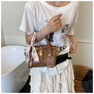 Brown PVC bucket bag with pink silk scarf detail and mini pouch on long shoulder strap