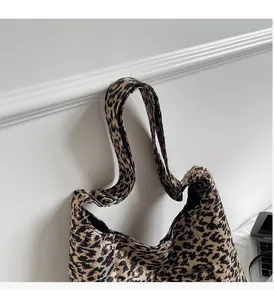 Detail of leopard print tote bag with adjustable wide strap and metallic buckle