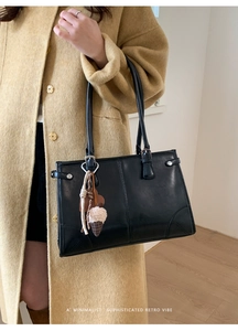Détail du sac bandoulière en cuir mat noir avec un pendentif mignon en forme de glace