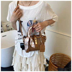 Detail shot of the silk scarf wrapped handle and metal lock on the transparent tote bag