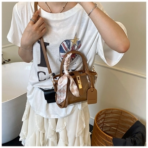 Brown PVC bucket bag with leather trim, silk scarf handle, and gold twist lock clasp
