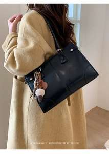 Détails du sac cabas en cuir noir avec ferrures argentées et porte-clés décoratif