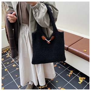 Detail of black faux fur tote bag featuring a vintage wooden horn buckle closure