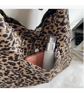 Detail of leopard print tote bag side pocket with metal magnetic closure and canvas texture