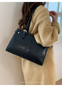 Vue latérale d'un sac porté épaule noir rétro minimaliste avec des boucles argentées