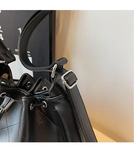 Détail de la bandoulière réglable et des garnitures argentées sur le sac fourre-tout