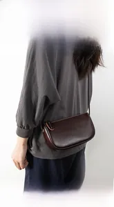 Detail view of smooth brown PU leather crossbody bag with minimalist rectangular design