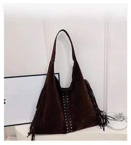 Dettaglio borsa hobo in pelle scamosciata marrone scuro con lunghe frange e borchie in metallo