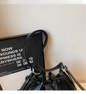 Détail du sac à dos seau en cuir noir avec fermeture à cordon et boucles argentées