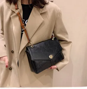 Détail du sac bandoulière noir en cuir texturé avec fermoir rotatif doré élégant