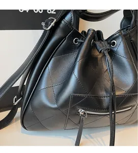 Détail du sac seau noir en cuir matelassé avec poche zippée et fermeture à cordon
