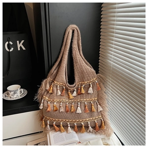 Détail d'un sac cabas en tricot marron avec franges colorées et finitions en peluche douce