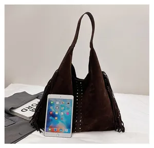 Vista dettagliata della borsa tote in pelle scamosciata marrone con borchie e frange