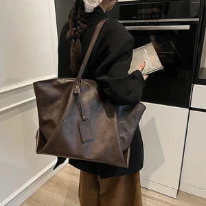 Minimalist large capacity dark brown leather tote bag for women worn over the shoulder