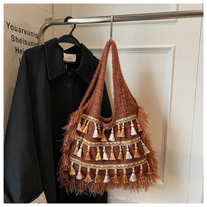 Détail du sac cabas bohème tissé marron avec pompons colorés et texture à franges