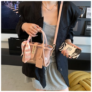 Modern pink transparent PVC bucket bag with silk scarf handle detail and crossbody strap
