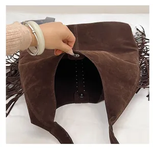 Dettaglio della borsa tote in pelle scamosciata marrone con frange e chiusura magnetica