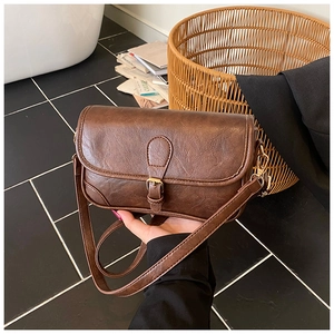 Detailed view of vintage caramel brown leather bag with golden hardware and textured finish